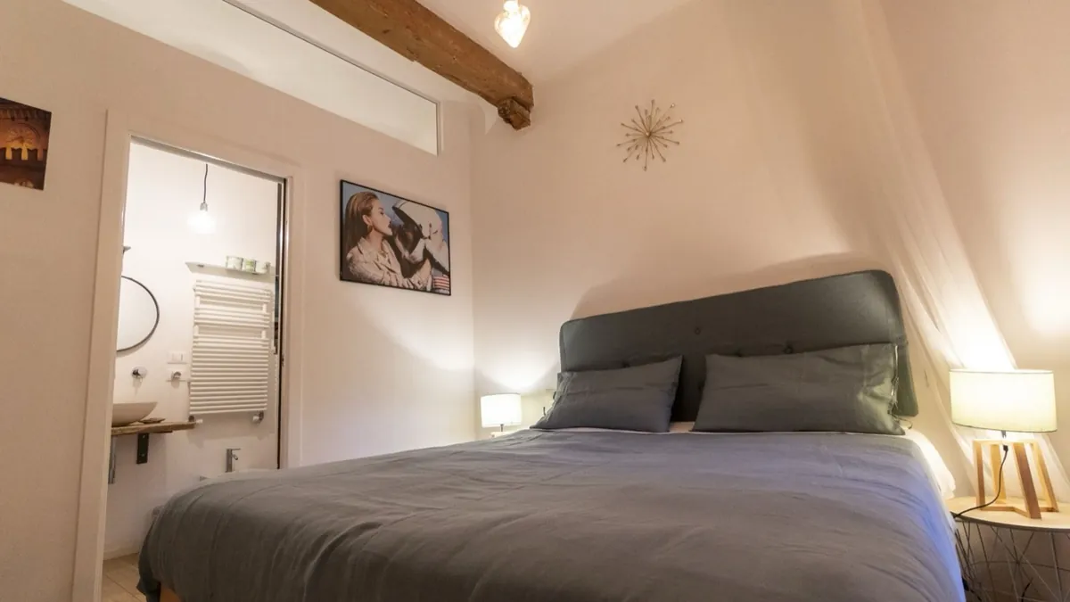 Studio D'Azeglio – letto sotto le travi in legno